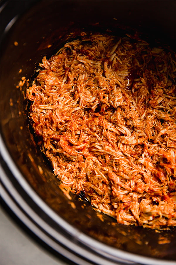 Shredded BBQ chicken in a slow cooker.