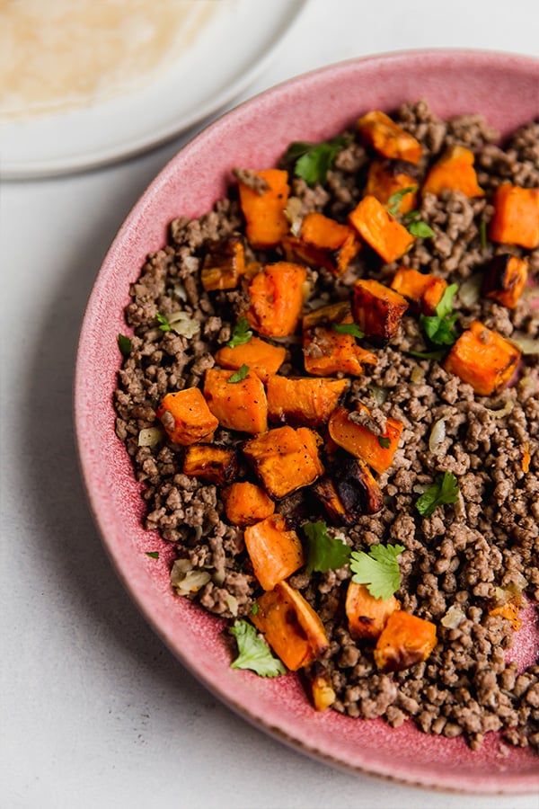 A bowl of sweet potato and beef filling for the taquitos.