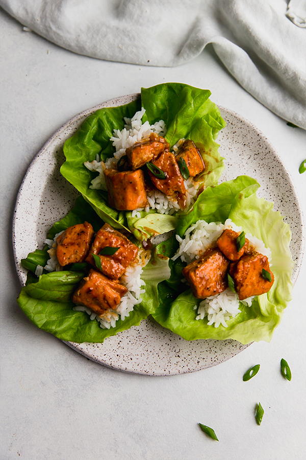 A plate with 3 firecracker salmon lettuce cups.