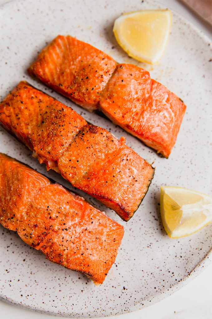 A plate with air fryer salmon filets sitting on it.