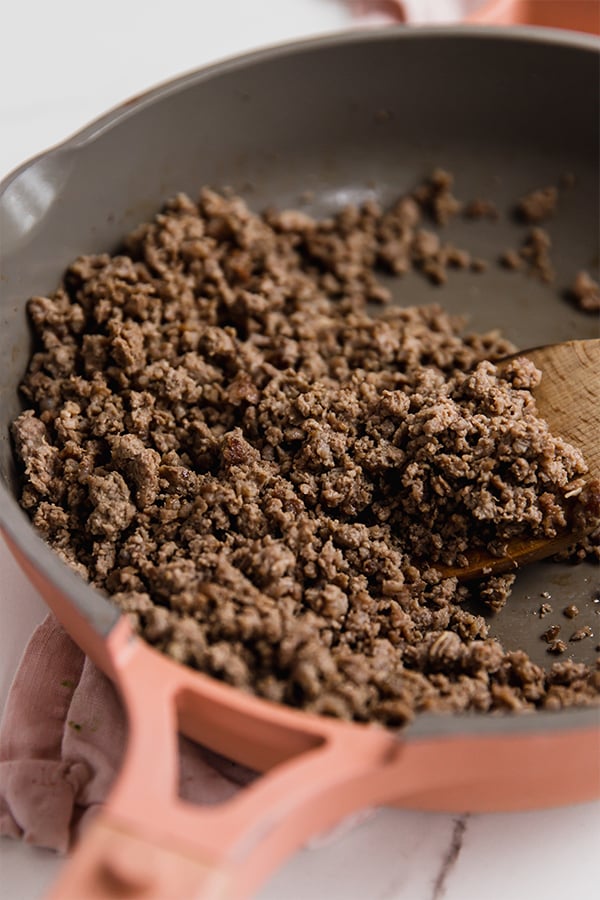 Ground beef browning in a pan.