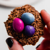 Person holding a chocolate coconut Easter egg nest.