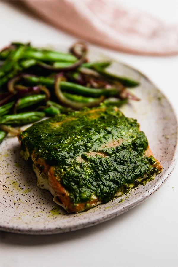 A serving of one-pan pesto salmon on a plate.
