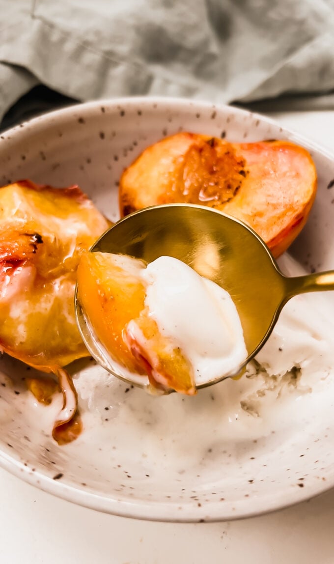 A bowl of air fried peaches with ice cream.