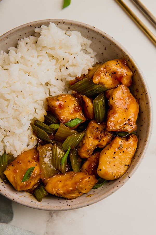 A bowl of black pepper chicken stir fry with rice.