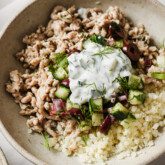Greek chicken bowls topped with tzatziki.