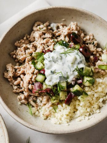 Greek chicken bowls topped with tzatziki.