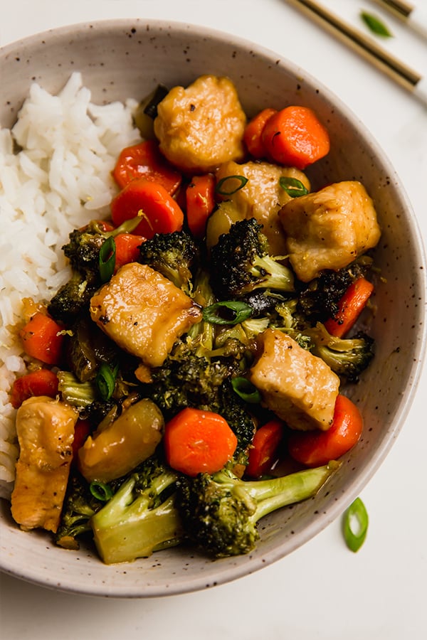 A bowl of lemon chicken & vegetable stir fry with rice.