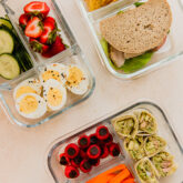 Three divided containers full of healthy foods.