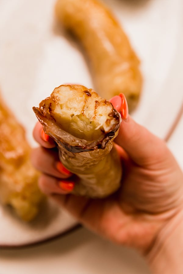 A Filipino Banana Lumpia being held in a hand.
