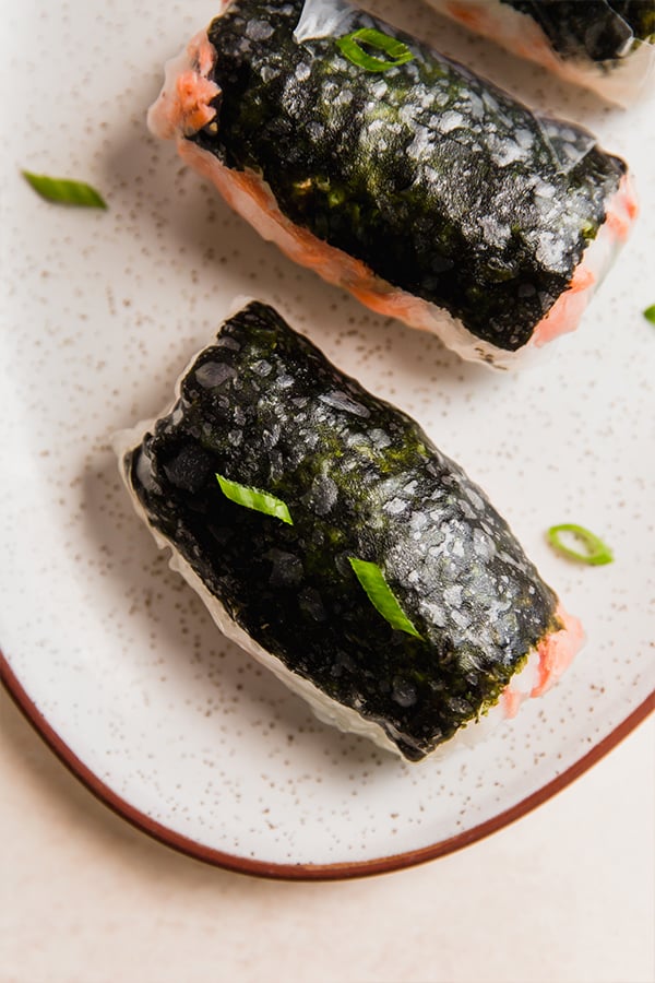 A serving plate with sushi-inspired salmon rice paper rolls.