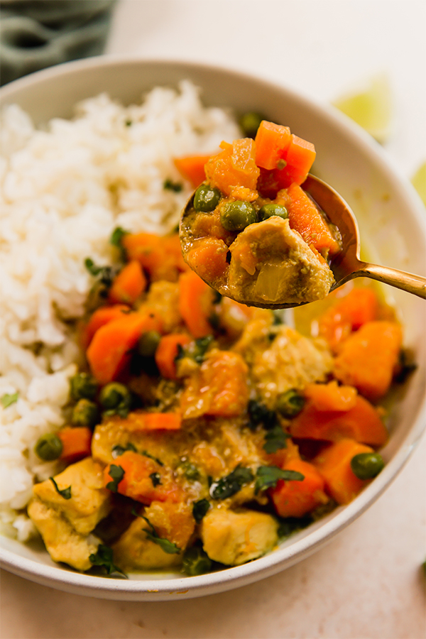 A bowl of slow cooker turmeric chicken curry with rice.
