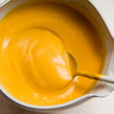Spoon in a bowl of dairy-free cheese sauce.