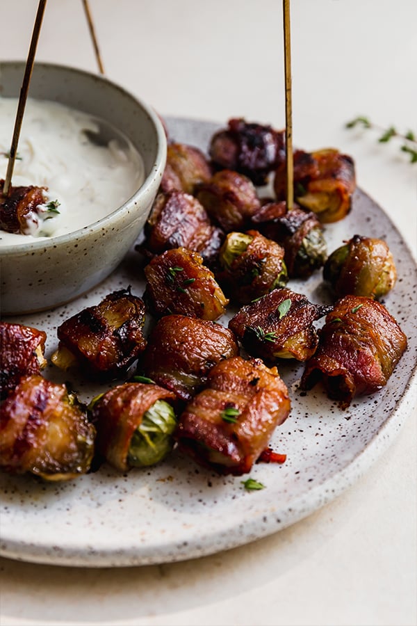 A plate with bacon wrapped brussels sprouts.