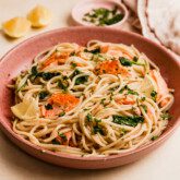 Lemon salmon pasta in a pink bowl.