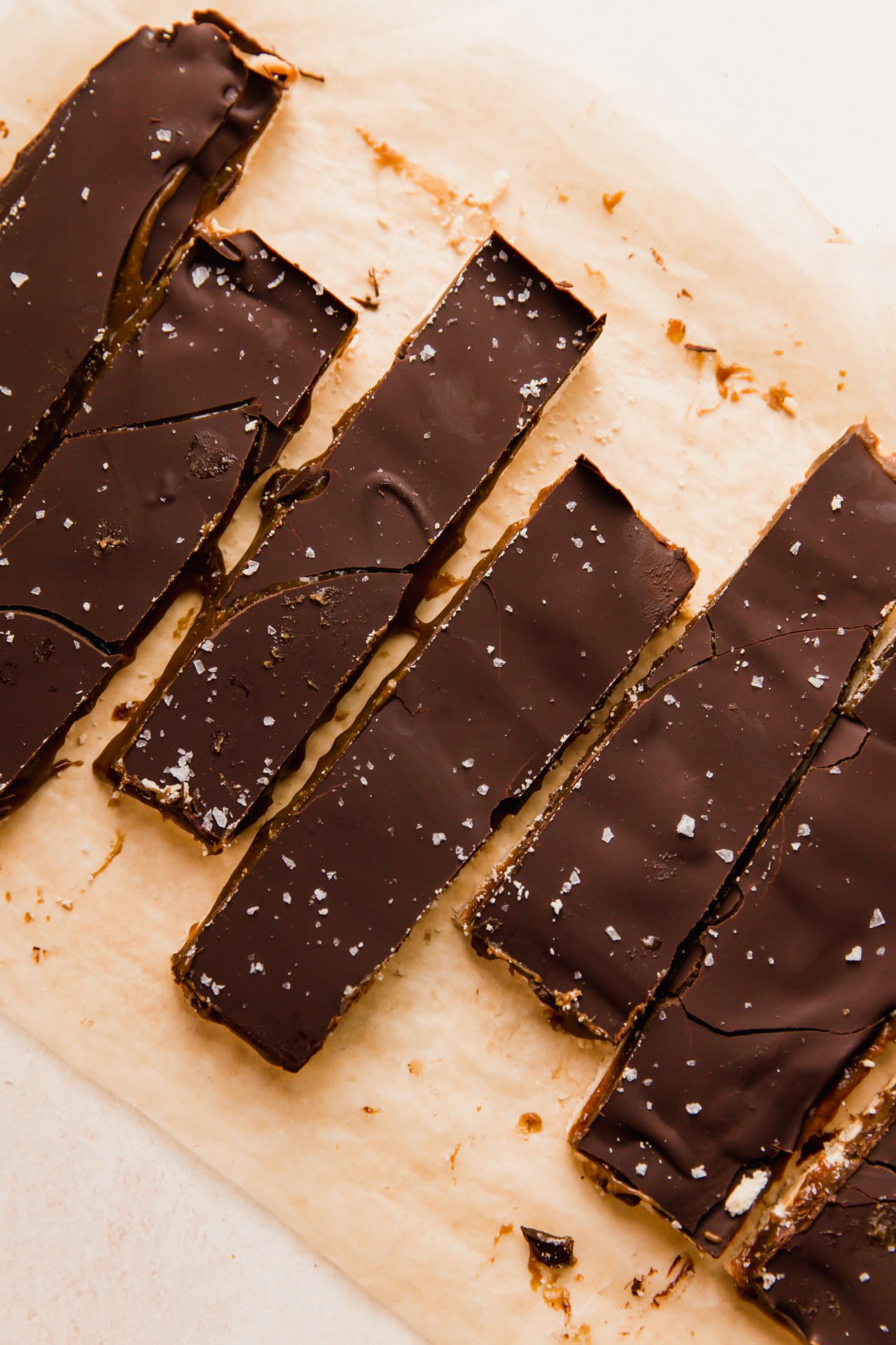 Twix bars sliced on a piece of parchment paper.