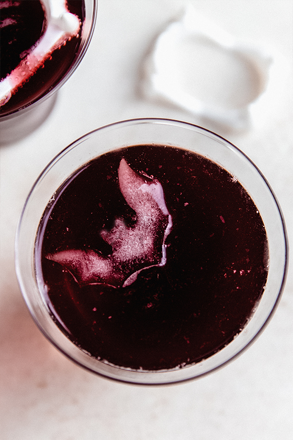 A glass of vampire mocktail with bat shaped ice cube