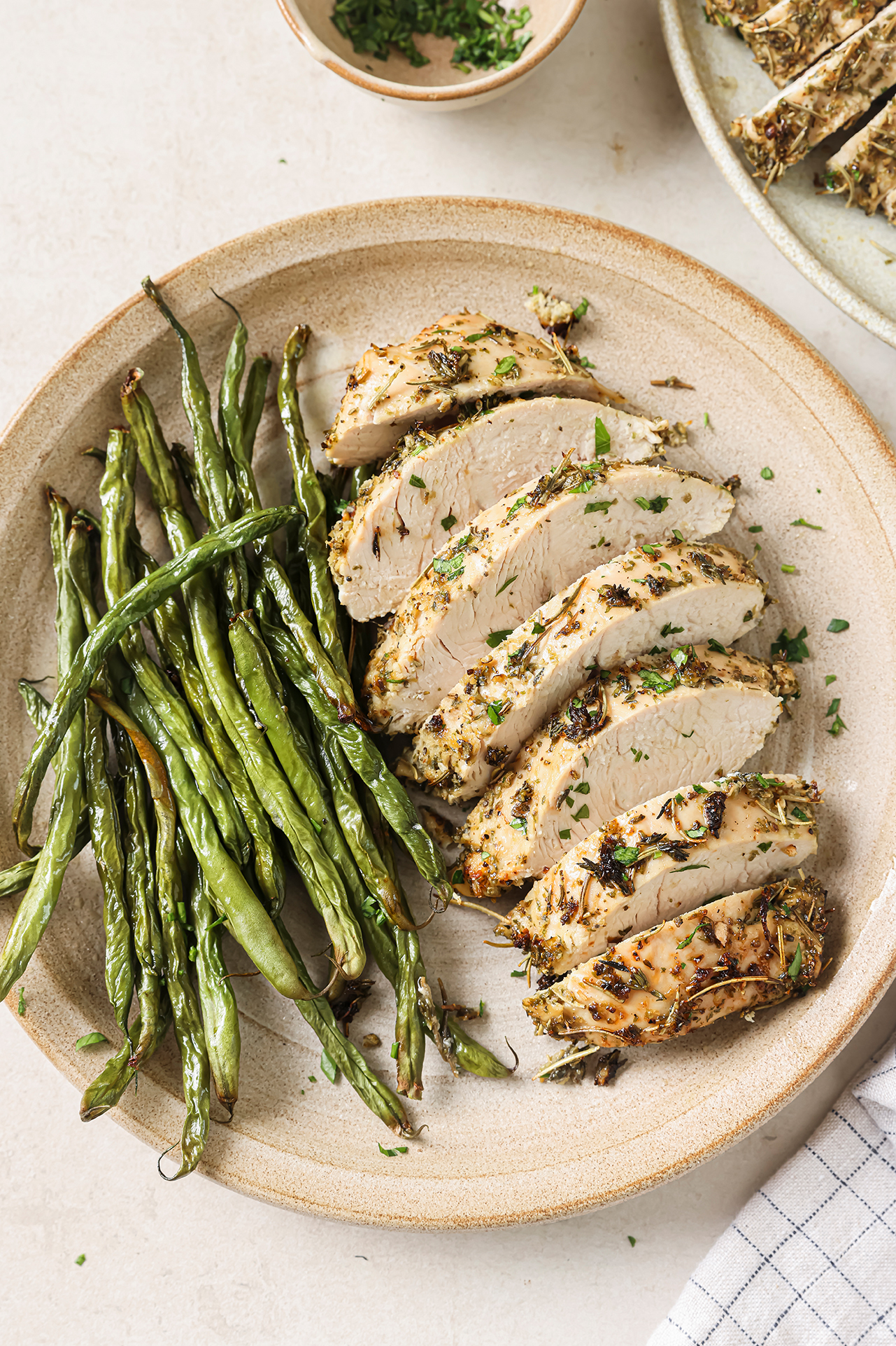 Turkey tenderloin sliced on a plate with green beans.