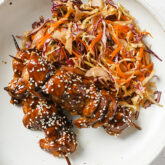 Teriyaki skewers on a plate with slaw.