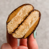 Person holding a homemade Tagalong cookie broken in half.