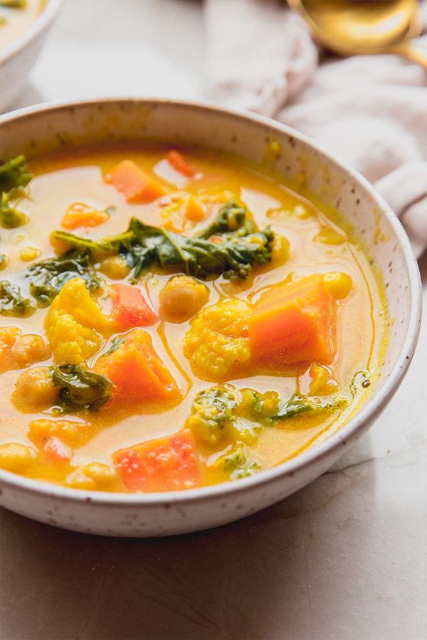 A bowl of golden chickpea and veggie soup