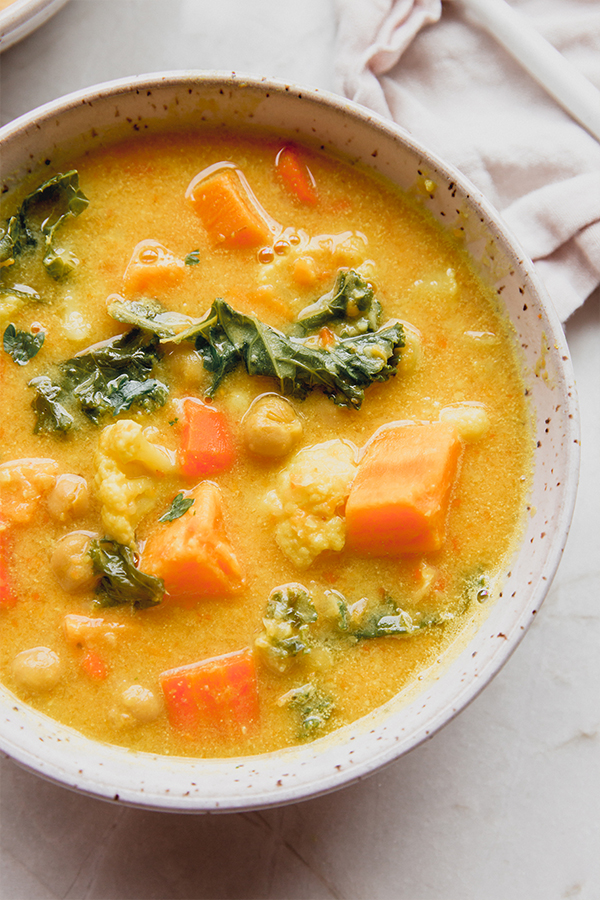 A bowl of golden chickpea and veggie soup.
