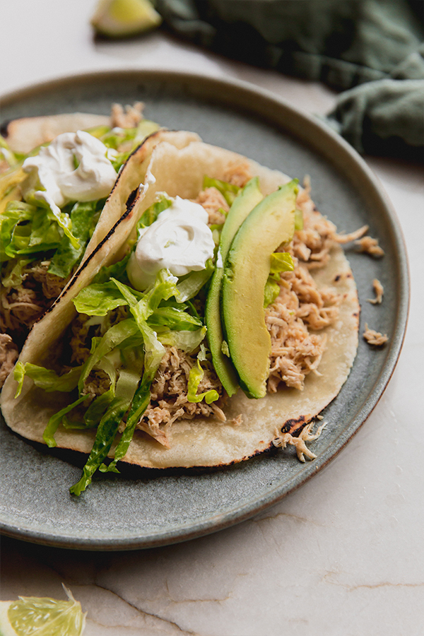 A plate with slow cooker ranch chicken tacos.