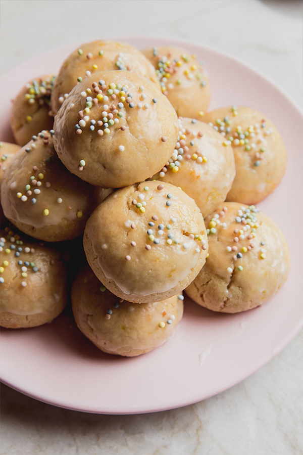 A plate of Italian Easter Cookies stacked with sprinkles.