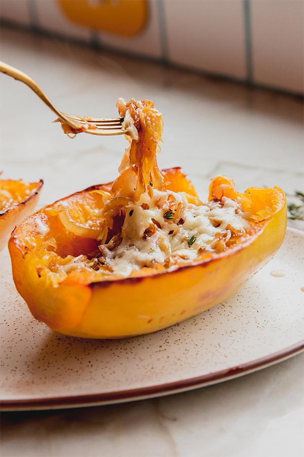 A french onion spaghetti squash boat with a fork in it.