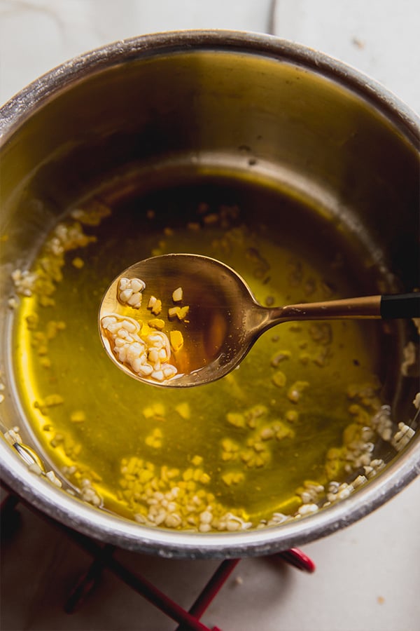 A bowl of olive oil and garlic mixture for coating the breadsticks.