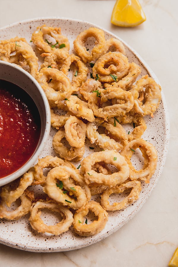 A plate of calamari with dipping sauce.