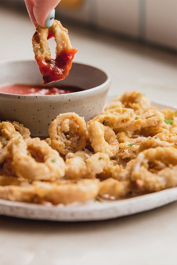 A plate of calamari after cooking and dipping into sauce.