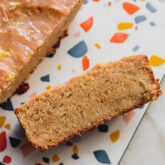 Slice of gluten-free lemon loaf on a colorful surface.