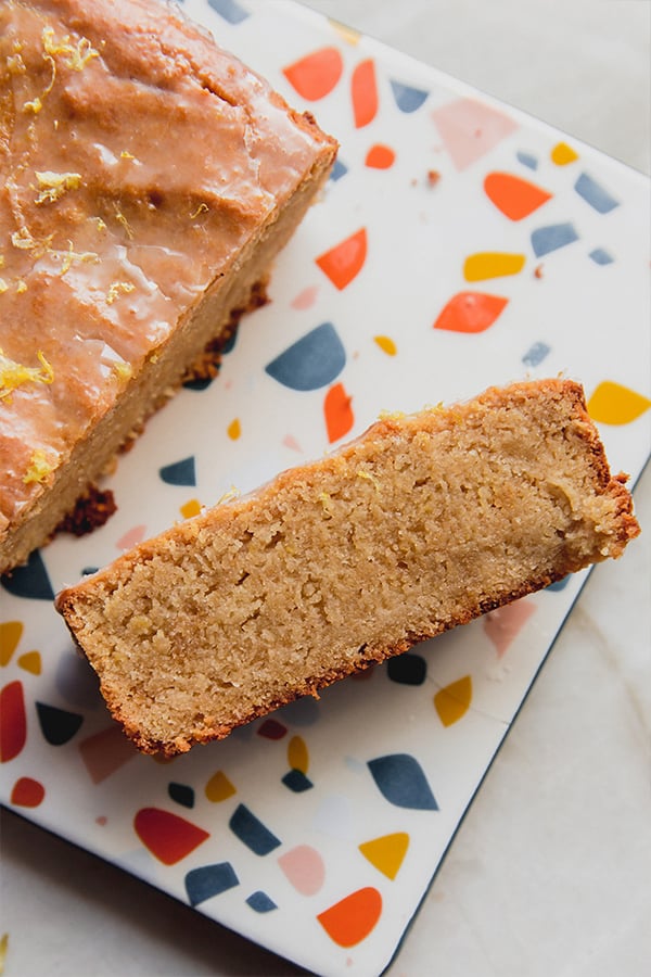 A slice of gluten-free lemon loaf cut off the loaf.