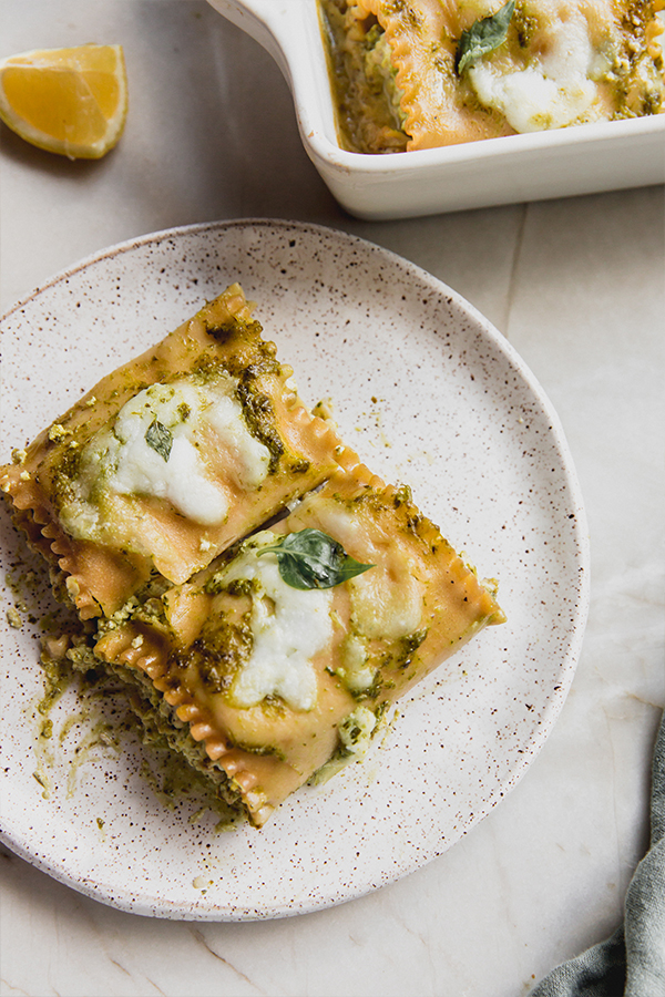 A plate with a serving of white pesto lasagna roll-up.
