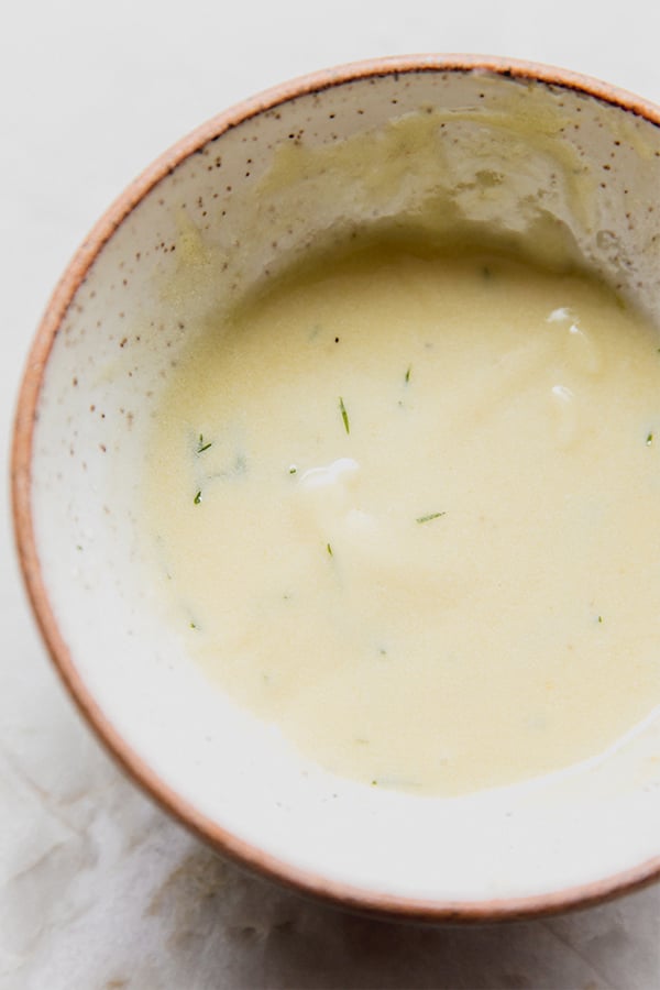 A bowl of salad dressing for everything bagel salmon salad.