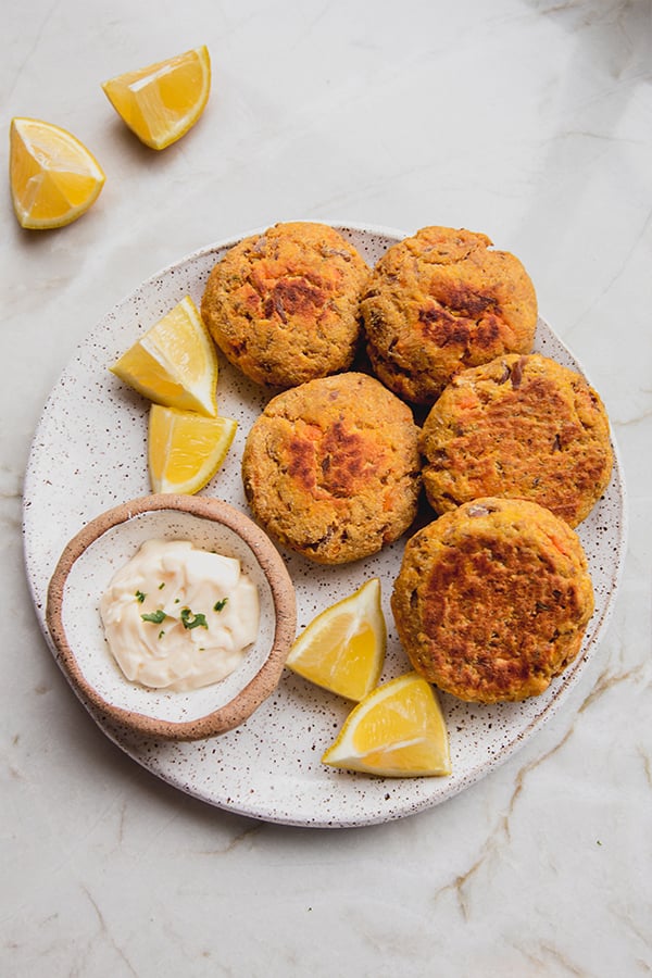 A plate of sweet potato tuna cakes with lemon and dip.