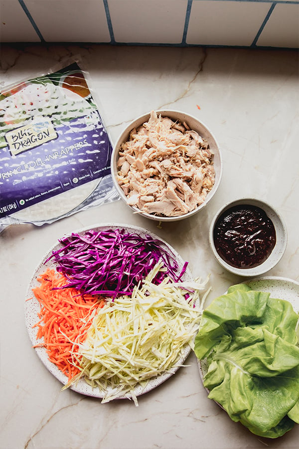 All the ingredients for chicken and vegetable spring rolls on the counter.