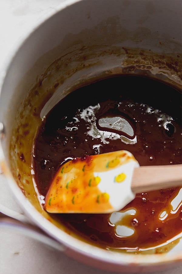 A bowl of orange syrup in a pot on the stove.