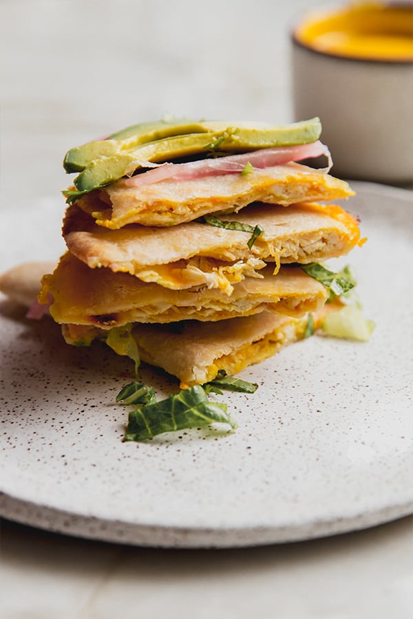 A stack of baked quesadilla pieces on a plate.