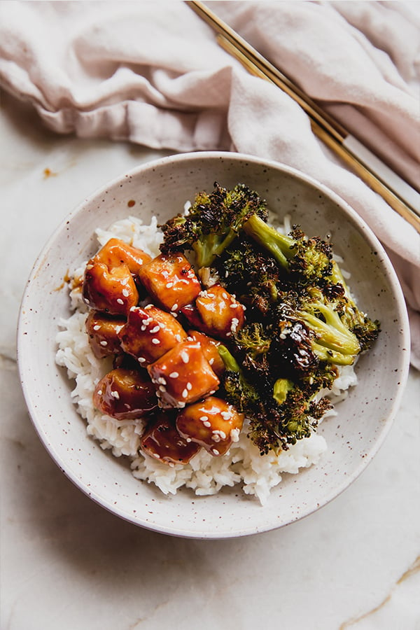 A bowl of sheet pan sesame chicken over rice.