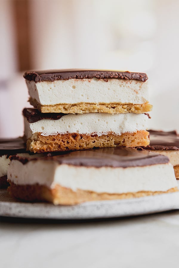 A plate of s'mores bars stacked and waiting to be eaten.