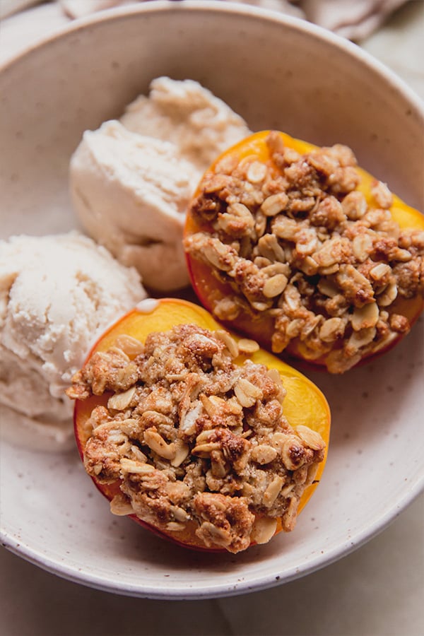 A bowl with air fryer peach crisp and dairy-free ice cream