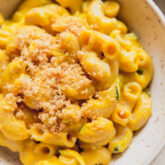 Zucchini mac and cheese topped with crumbs.