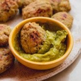 A plate with zucchini chicken nuggets and dipping sauce.