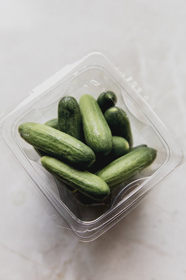 A container of cucumbers before pickling.