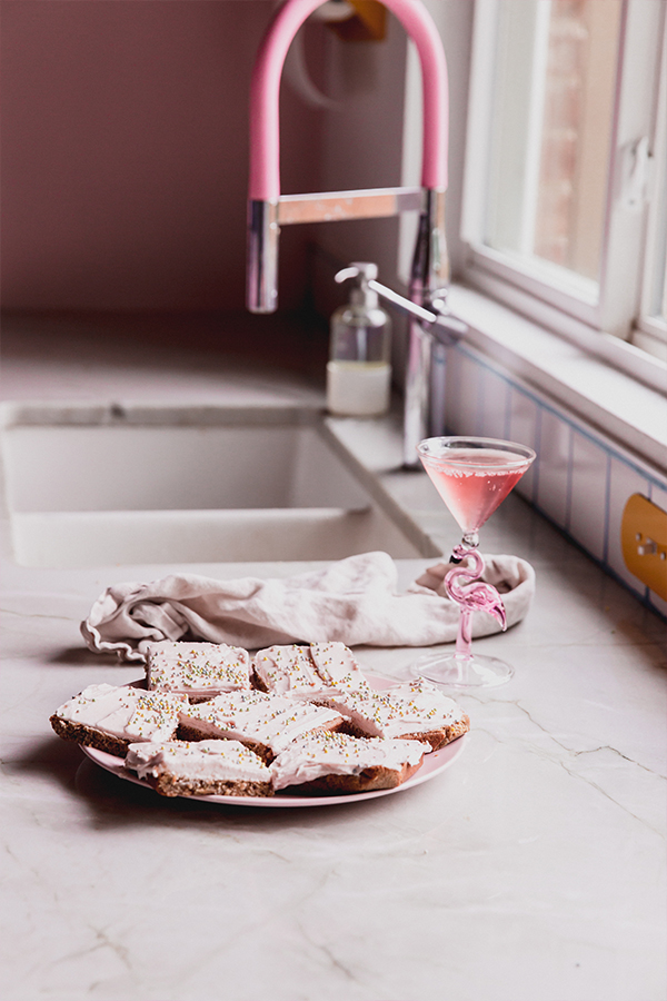 A plate of funfetti pink sugar cookie bars on the counter.