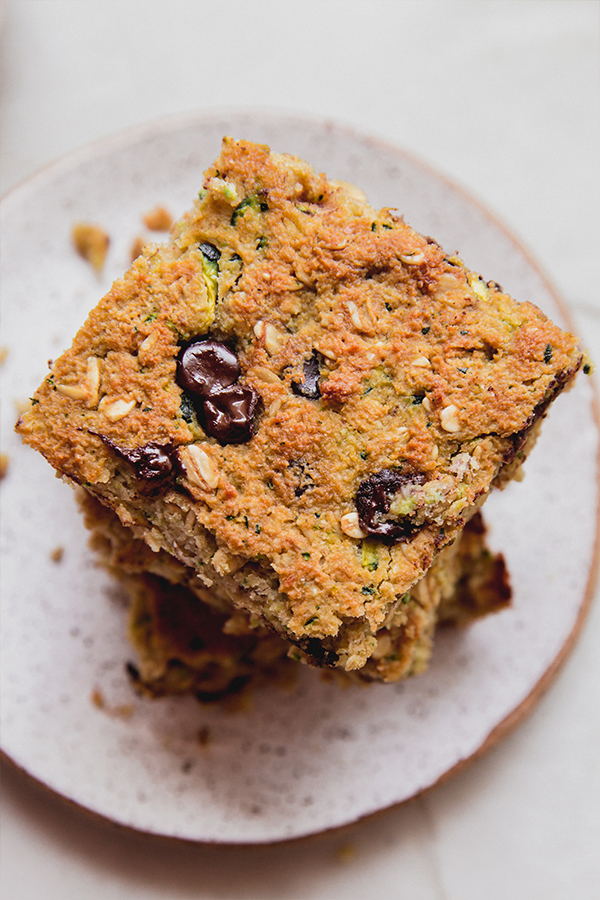 A stack of zucchini banana breakfast bars on a plate ready to enjoy!