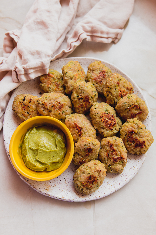 A plate of zucchini chicken nuggets with dipping sauce.