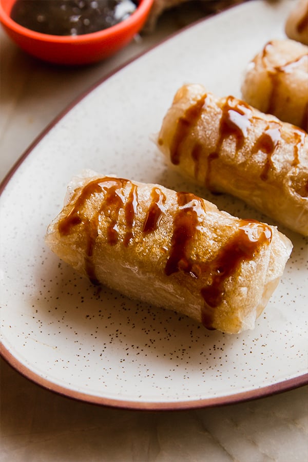 A serving platter with caramel apple rice paper rolls.